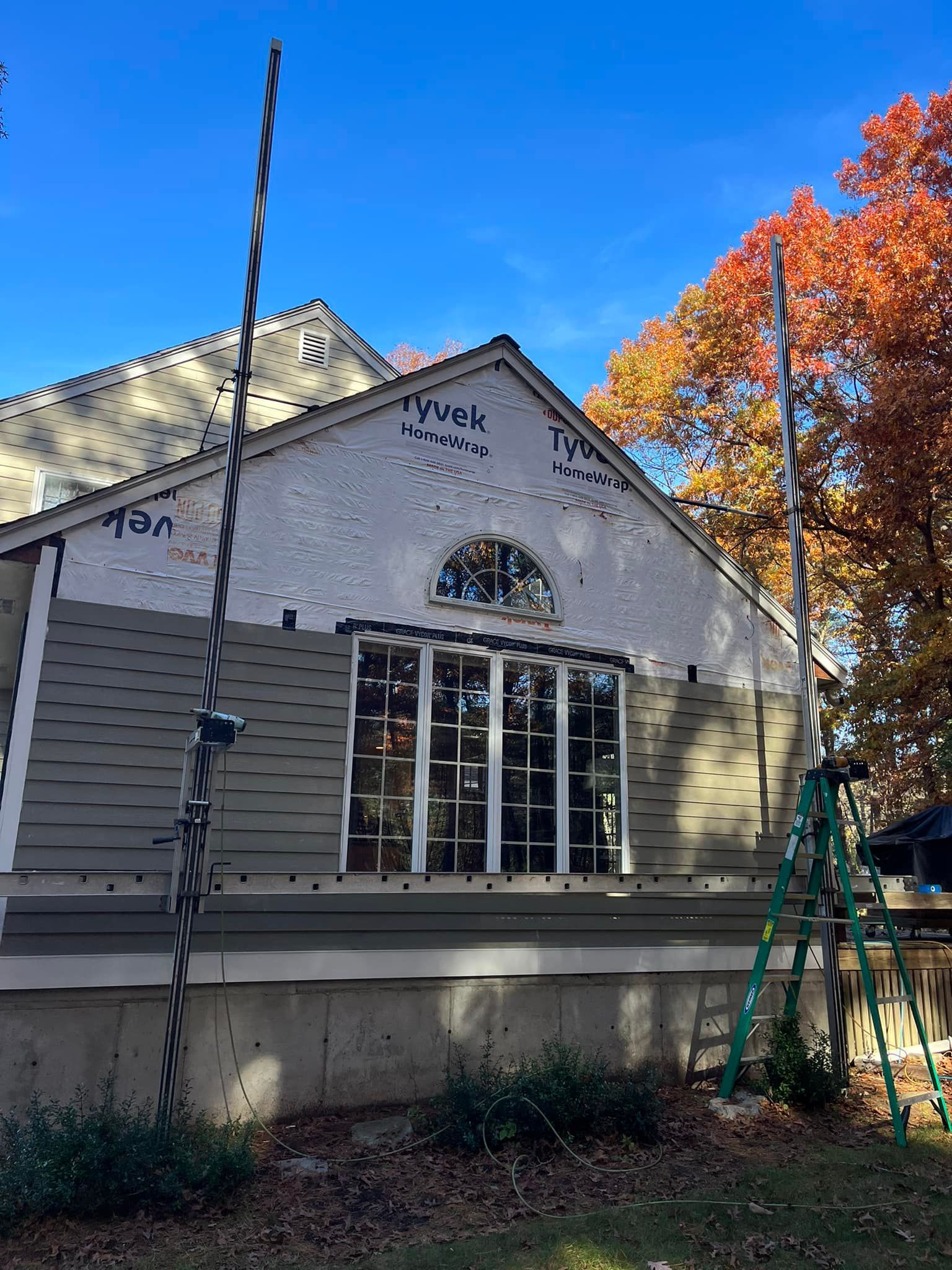 A house is being remodeled with a ladder in front of it.