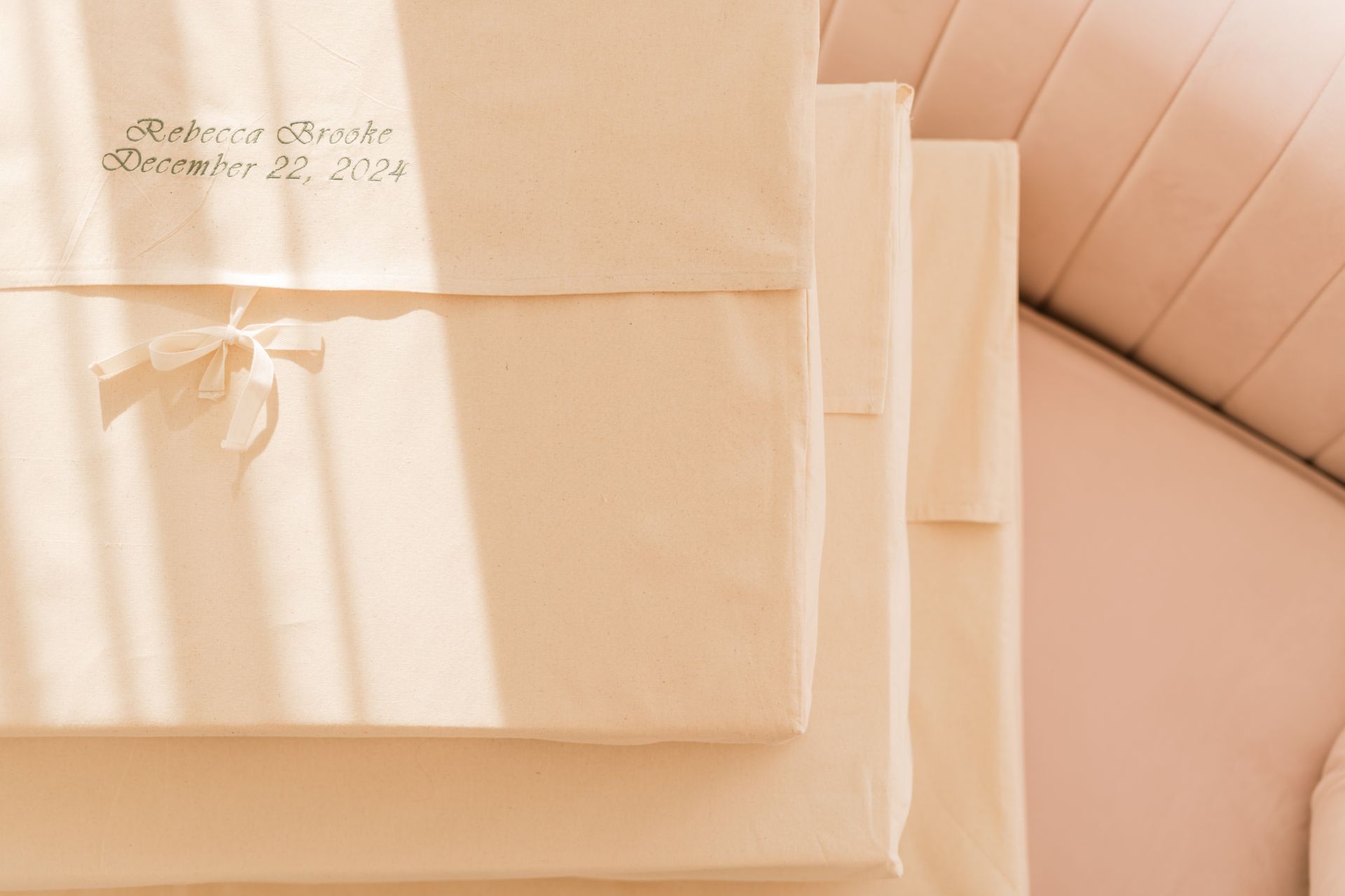 Cream-colored boxes stacked. One has a bow and text: 