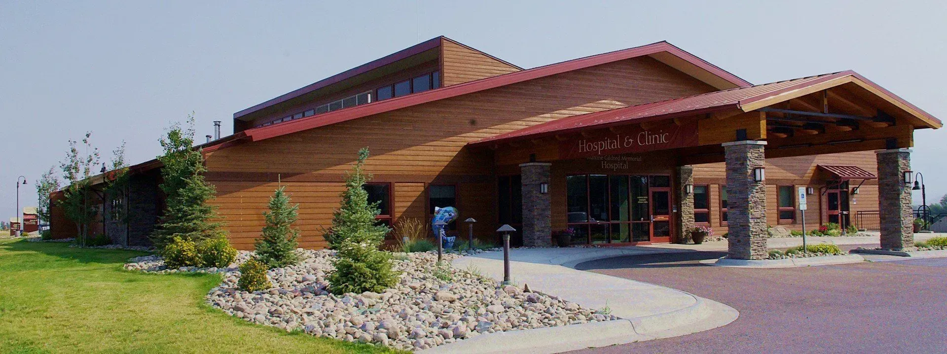Wooden hospital building with stone pillars.