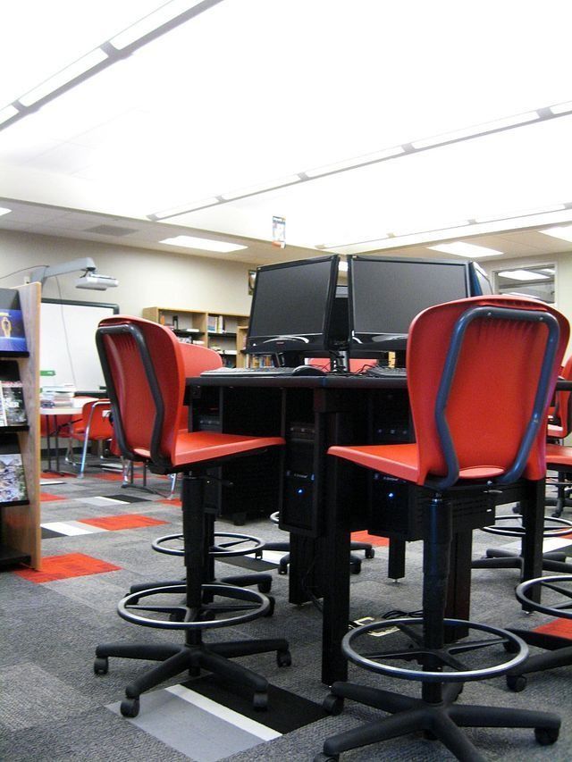 A classroom with red chairs and computer desks.