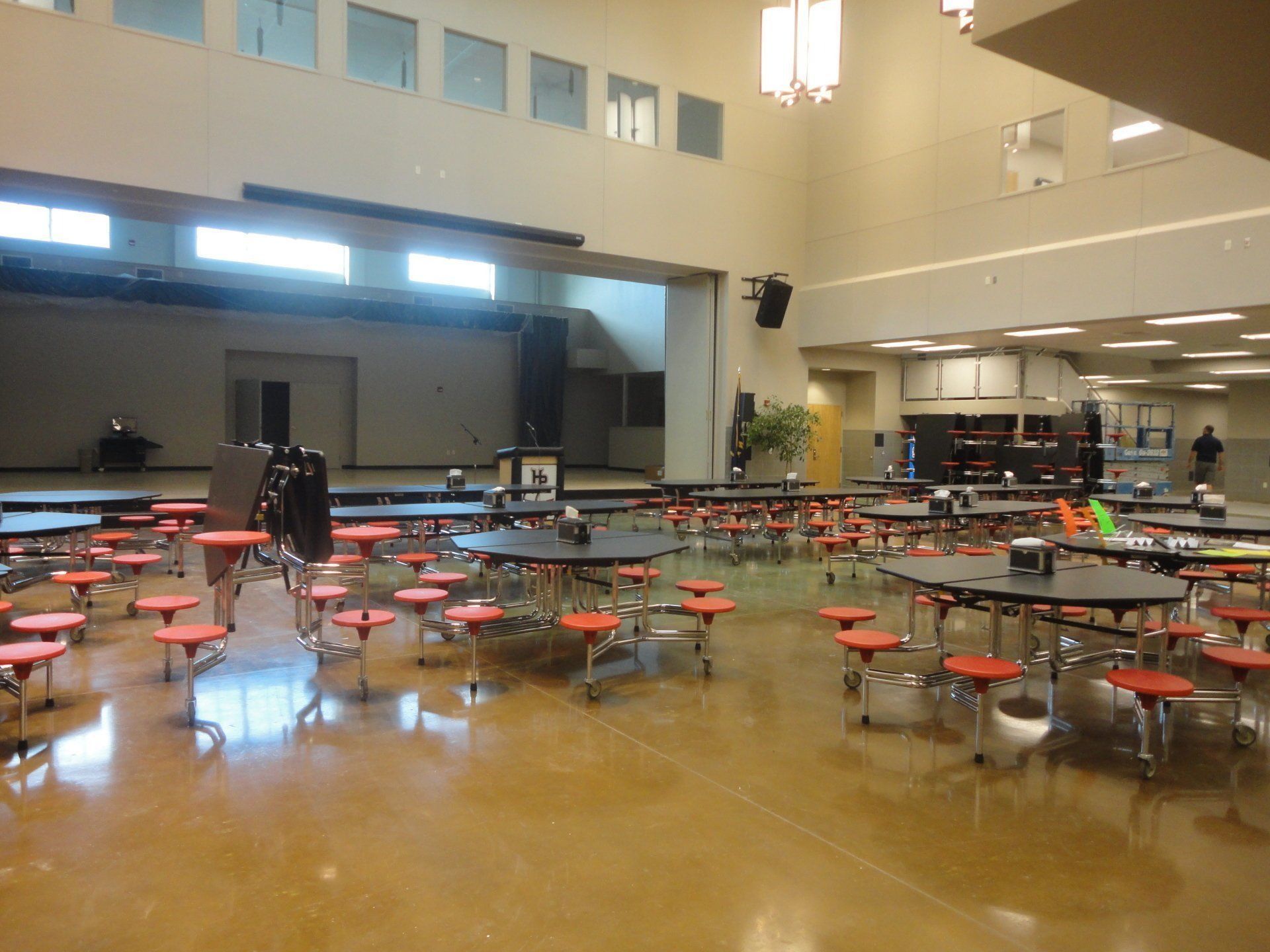 An empty school cafeteria with tables and chairs.