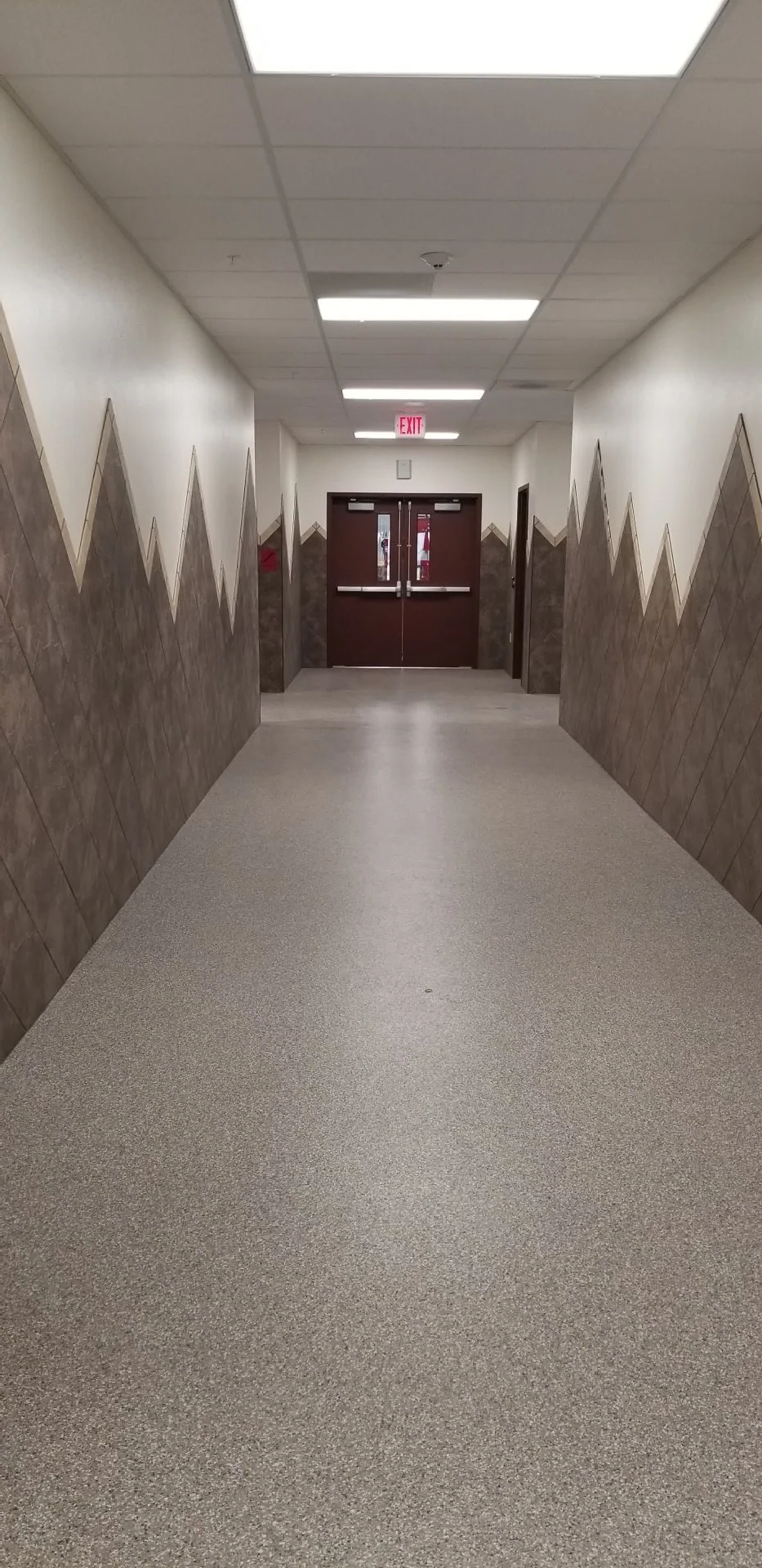 A long hallway with trees painted on the walls.