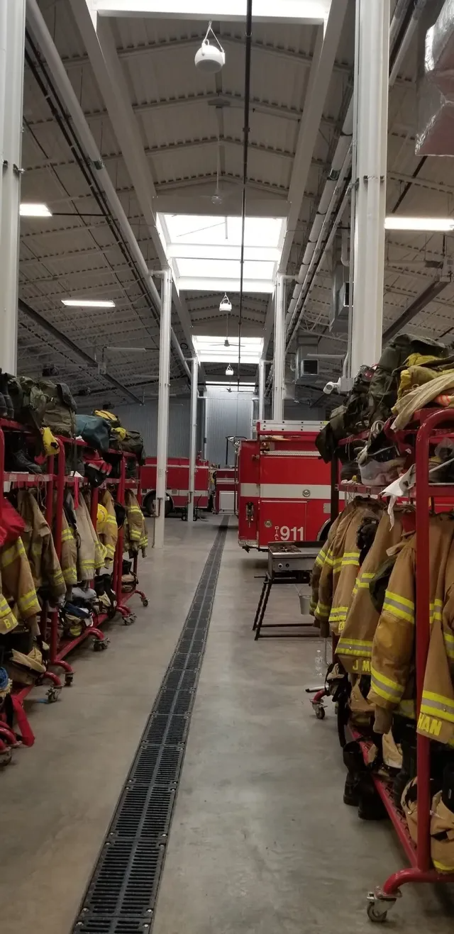 A fire station garage with fire trucks parked inside.