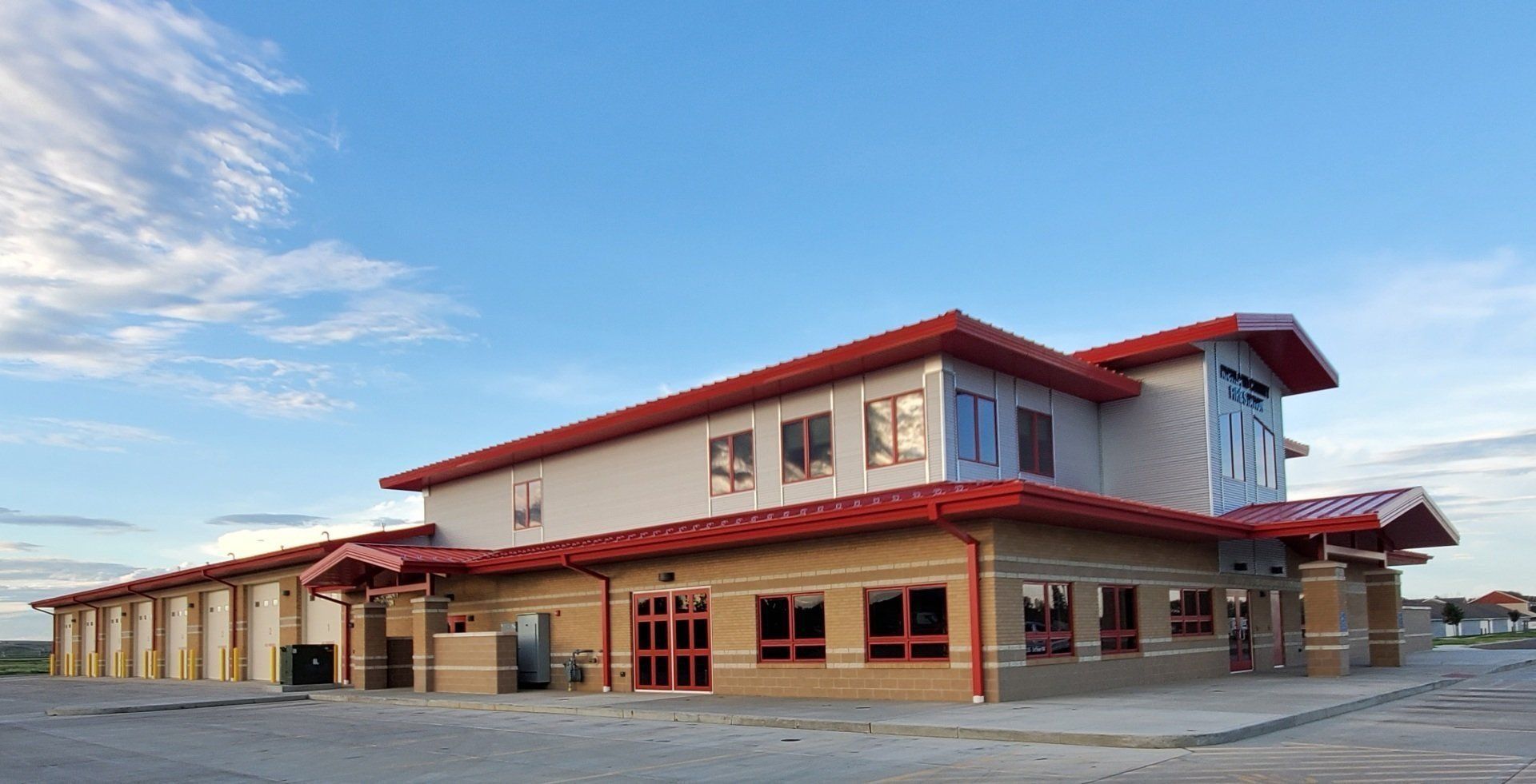 A large building with a red roof and a blue sky in the background.