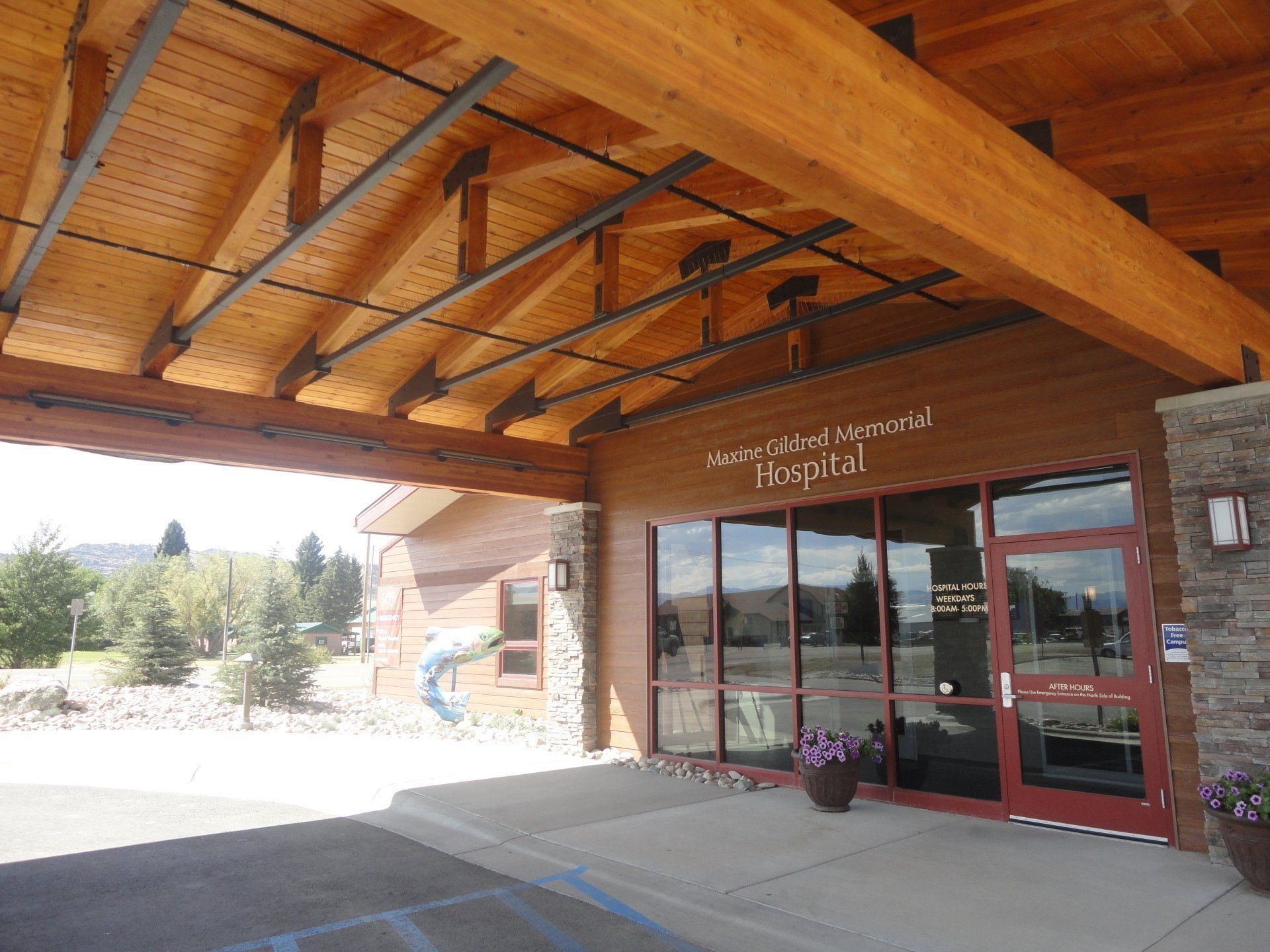 The entrance to a hospital with a wooden roof.