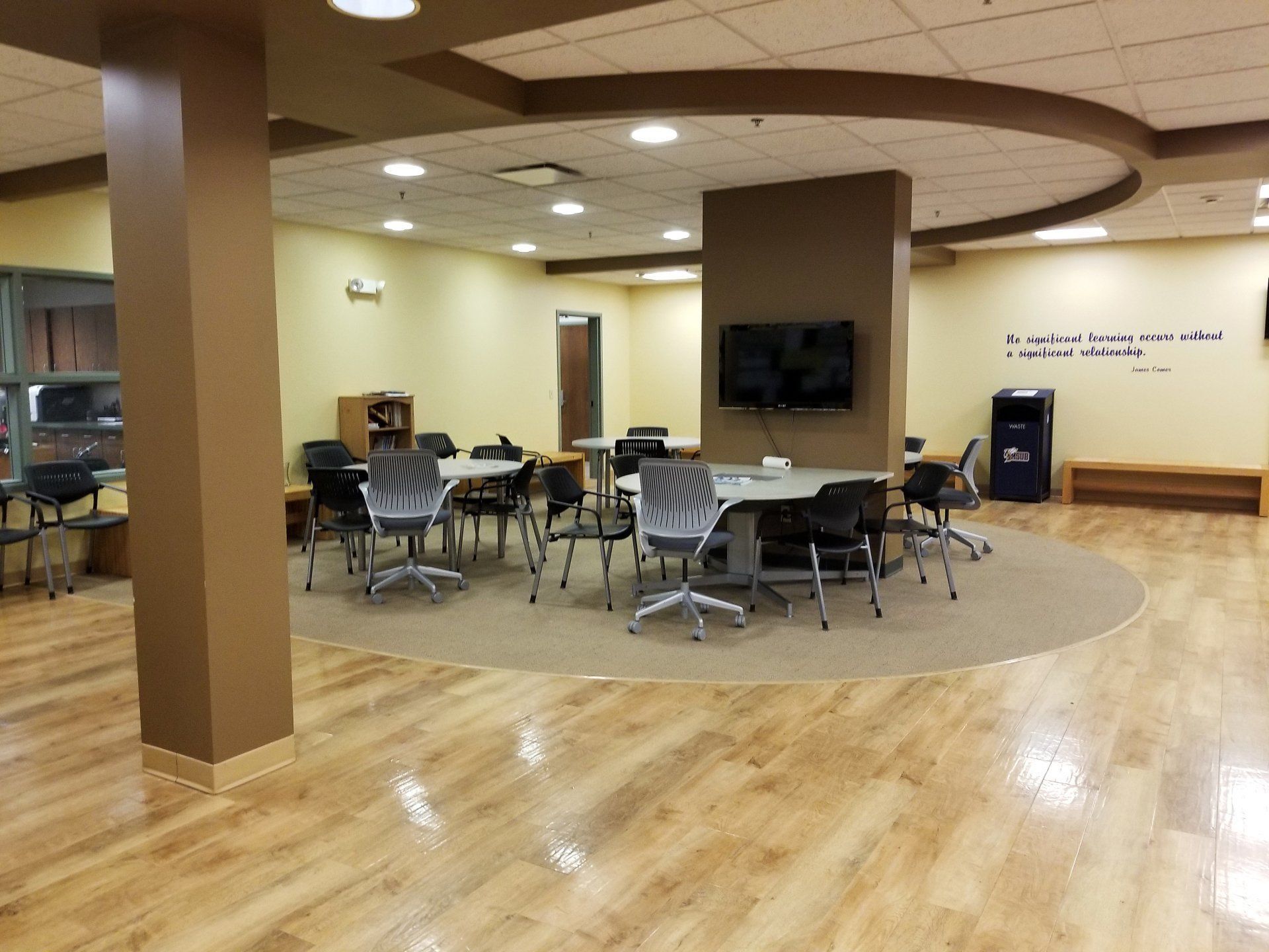 A modern study room with round tables and chairs.