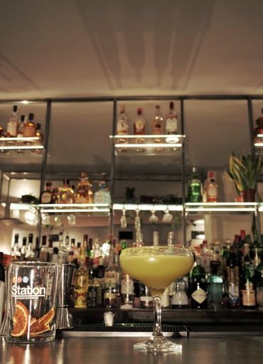 A glass with the word stadon on it sits on a bar