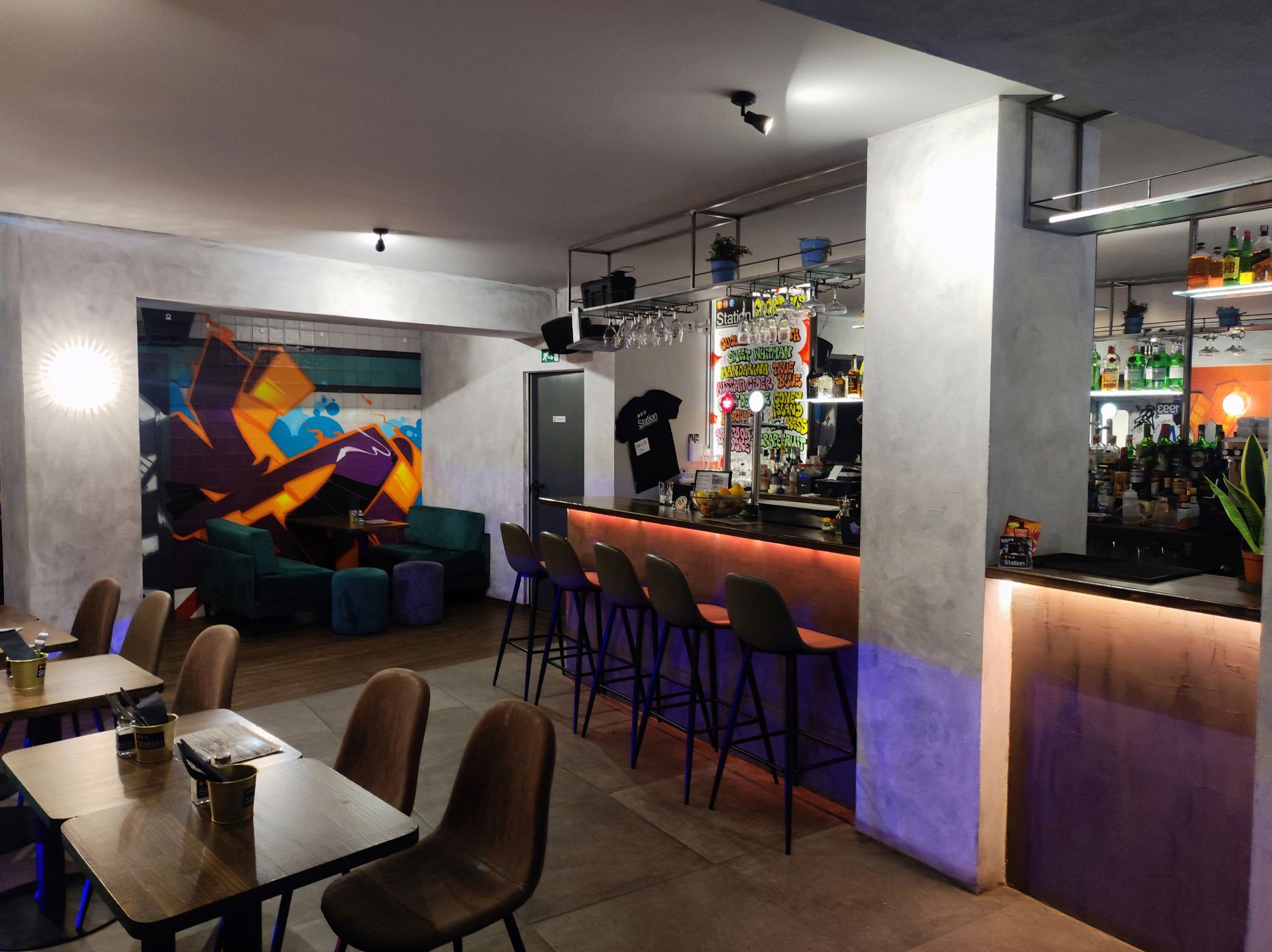 A restaurant with tables and chairs and a bar.