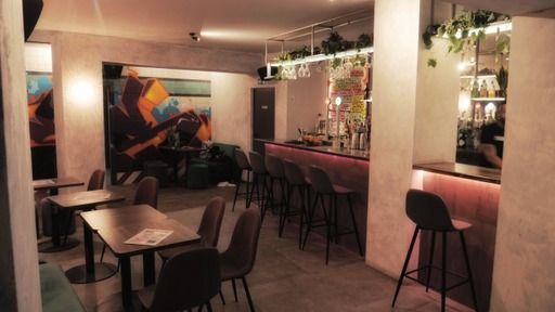 A restaurant with tables and chairs and a bar.