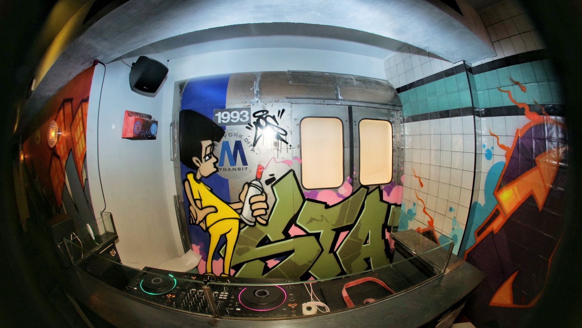 A fisheye lens shows graffiti on a wall that says 1993