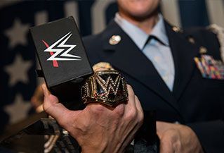 A man in a military uniform is holding a wrestling ring.