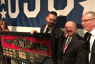 A group of men are holding a wwe championship belt