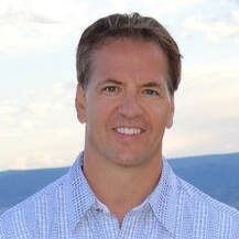 A man in a plaid shirt is smiling for the camera.