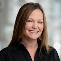 A woman in a black shirt is smiling for the camera.