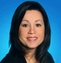 A woman is smiling in front of a blue background
