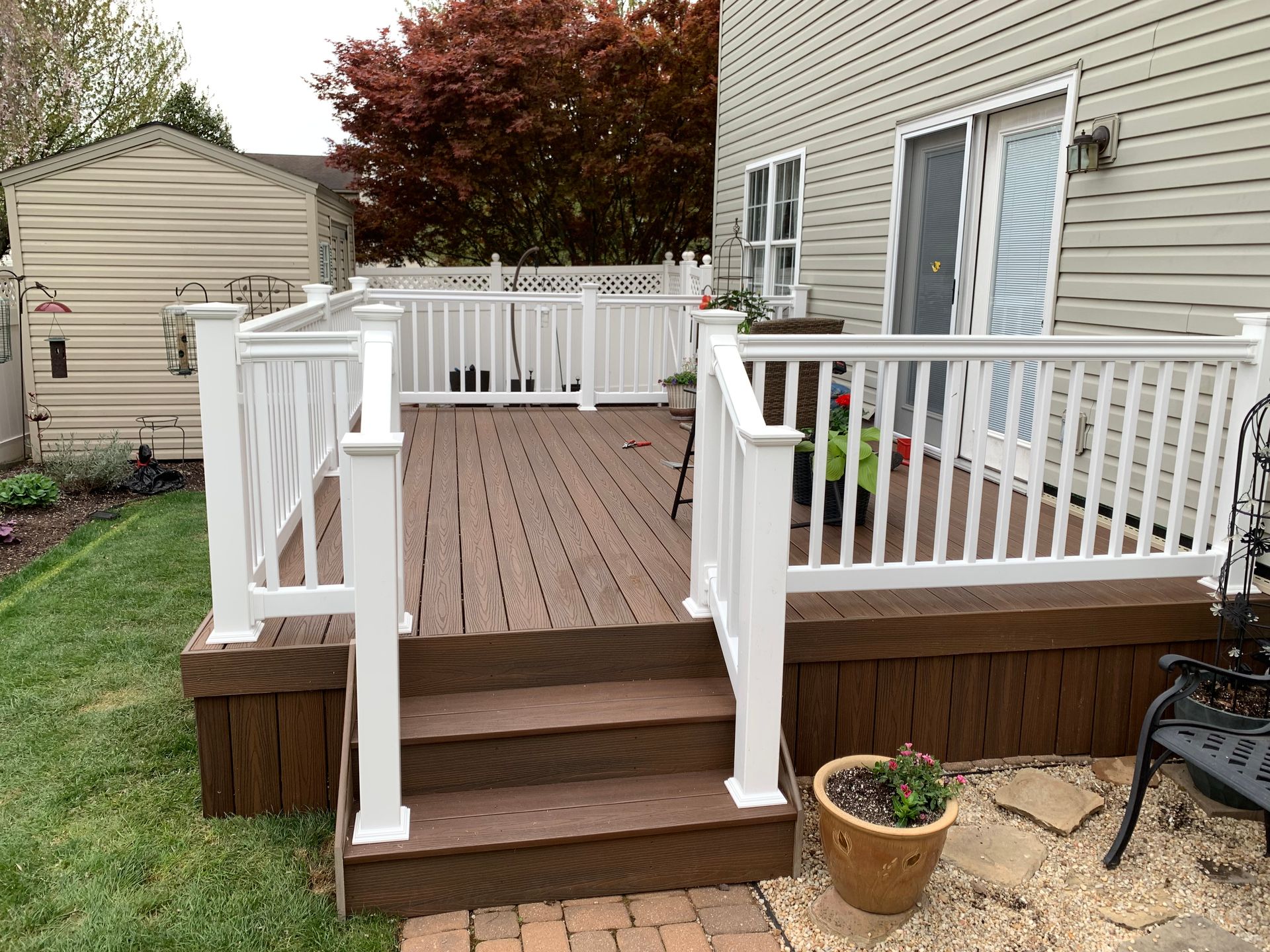 Remodeling Experts deck builder contractor custom deck along pool. Deck details... maintenance free composite decking with white vinyl railing 