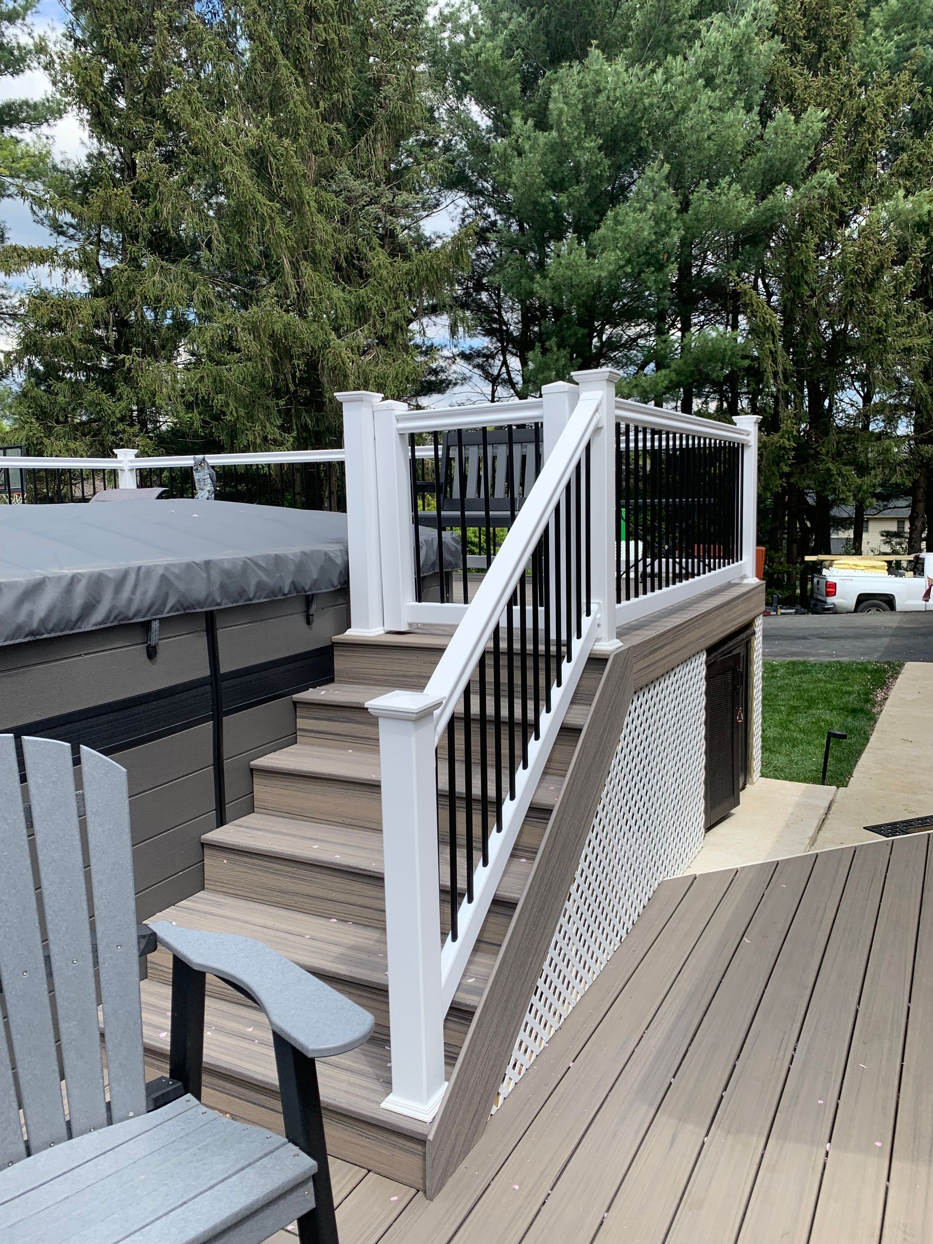 Remodeling Experts deck builder contractor custom maintenance free composite decking with white vinyl railing along hot tub