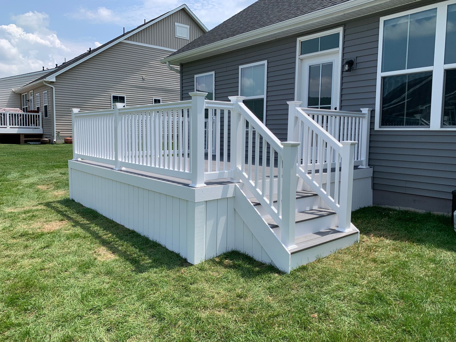Remodeling Experts deck builder contractor custom deck along pool. Deck details... maintenance free composite decking with white vinyl railing 