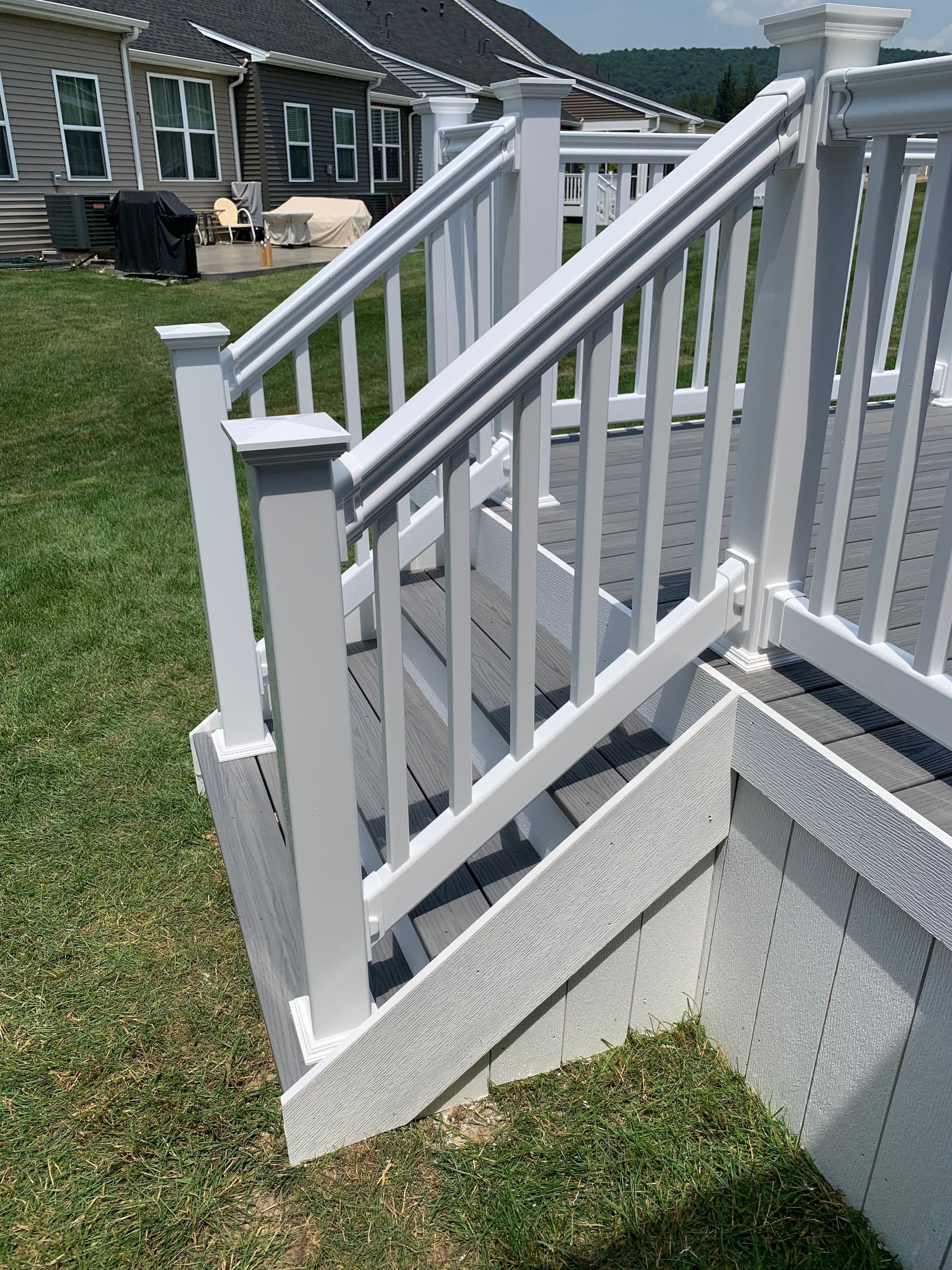 Remodeling Experts deck builder contractor custom deck along pool. Deck details... maintenance free composite decking with white vinyl railing 