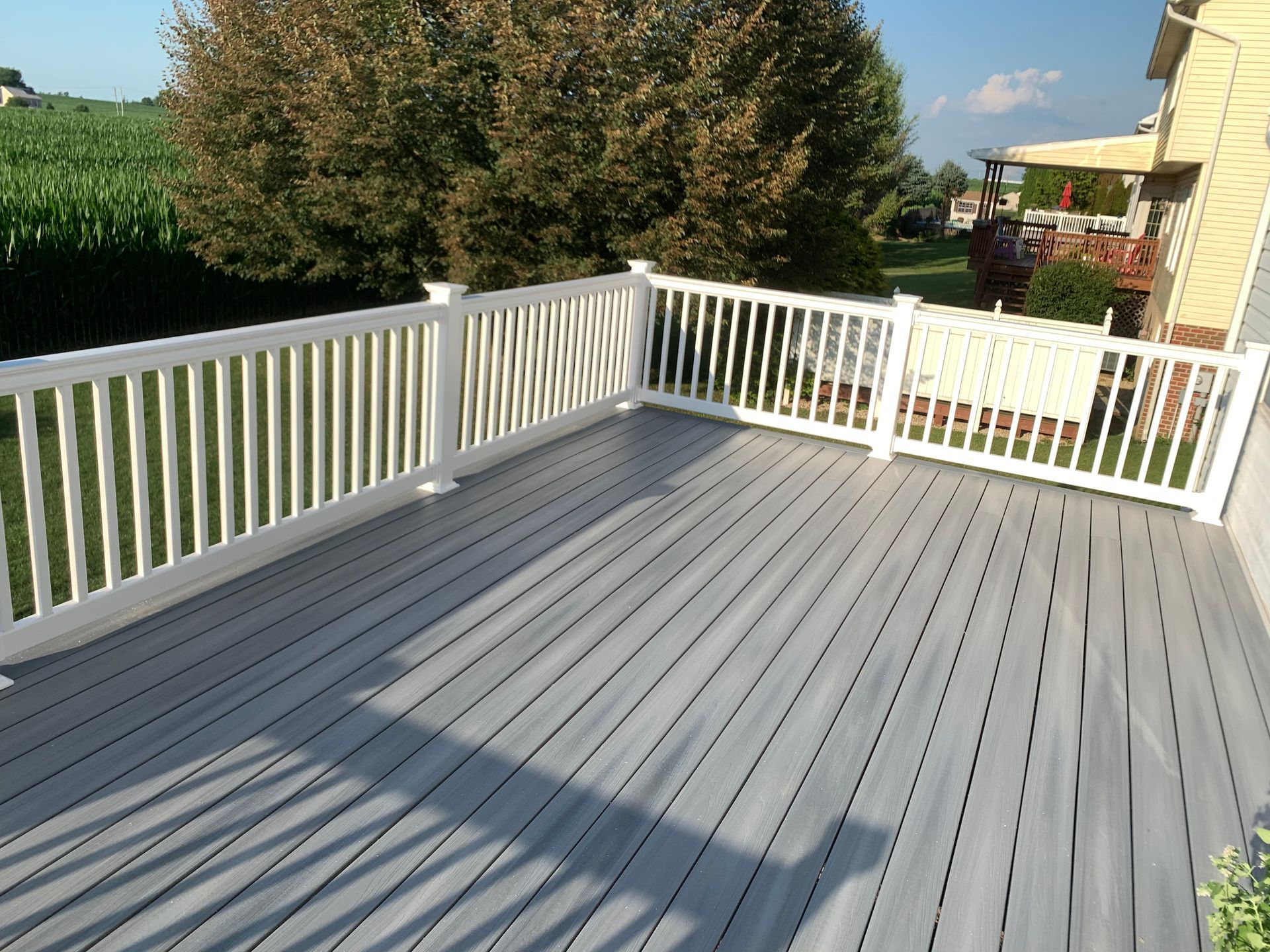 Remodeling Experts deck builder contractor custom deck along pool. Deck details... maintenance free composite decking with white vinyl railing 