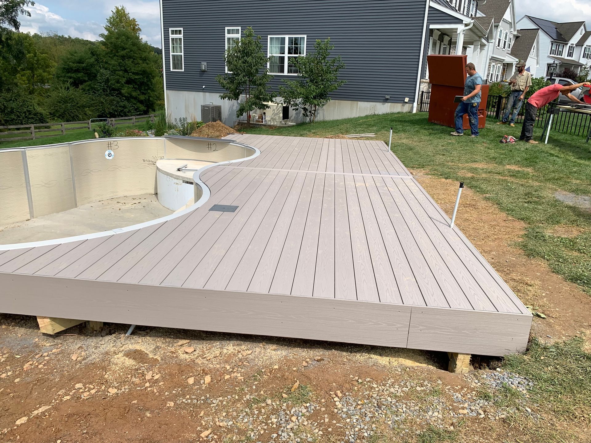 Remodeling Experts deck builder contractor custom maintenance free composite decking beside the new pool.