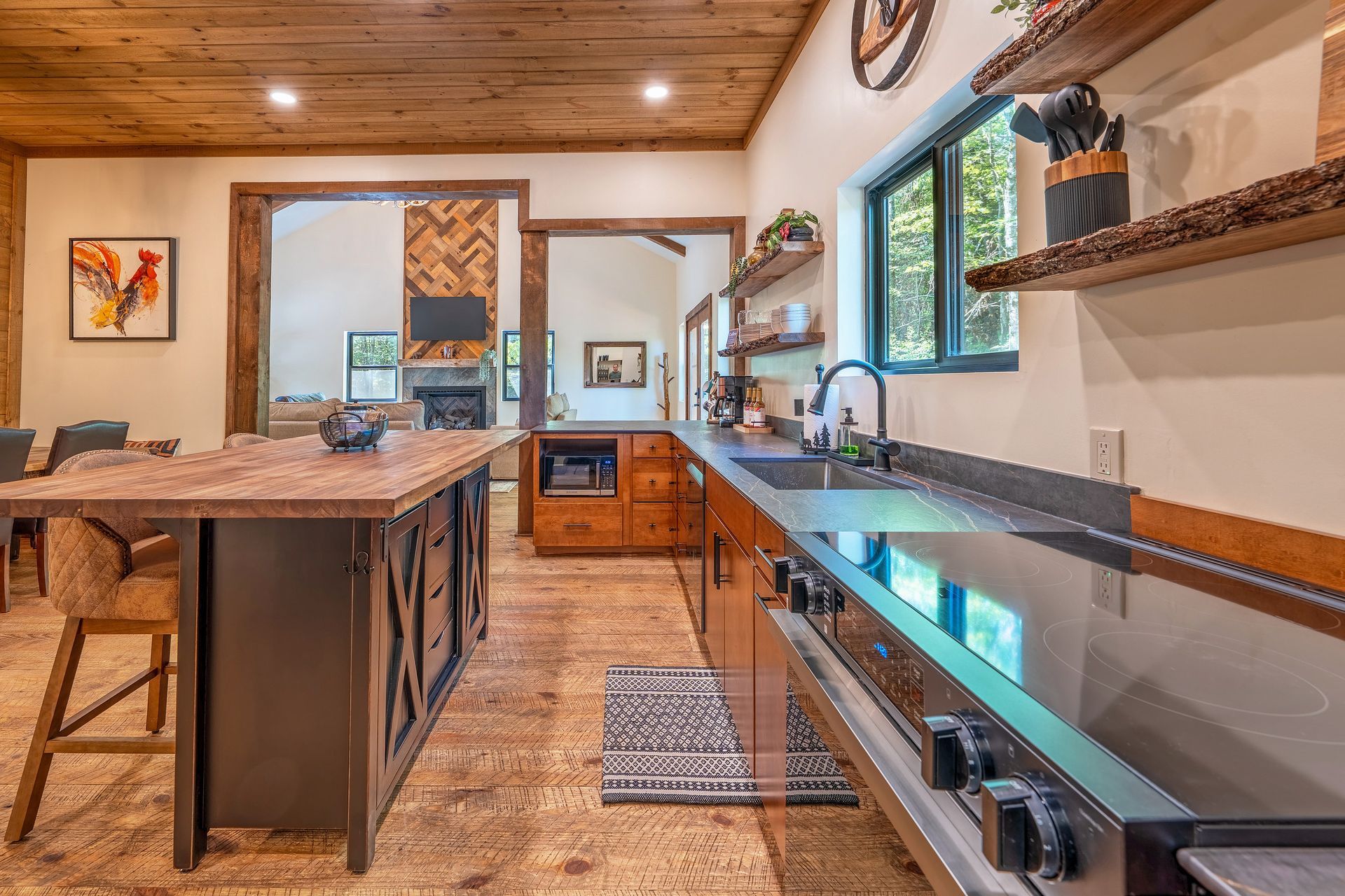 Modern kitchen with wood ceiling, island, stainless stove, and large window