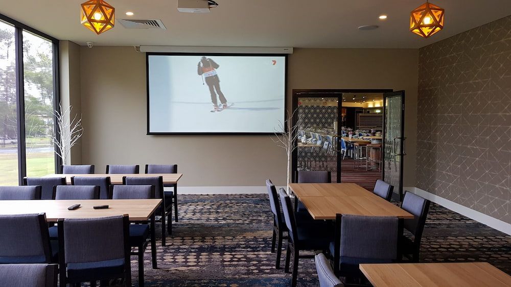 A Room With Tables and Chairs and a Projector Screen — Inspired Audio Visual in Coffs Harbour, NSW