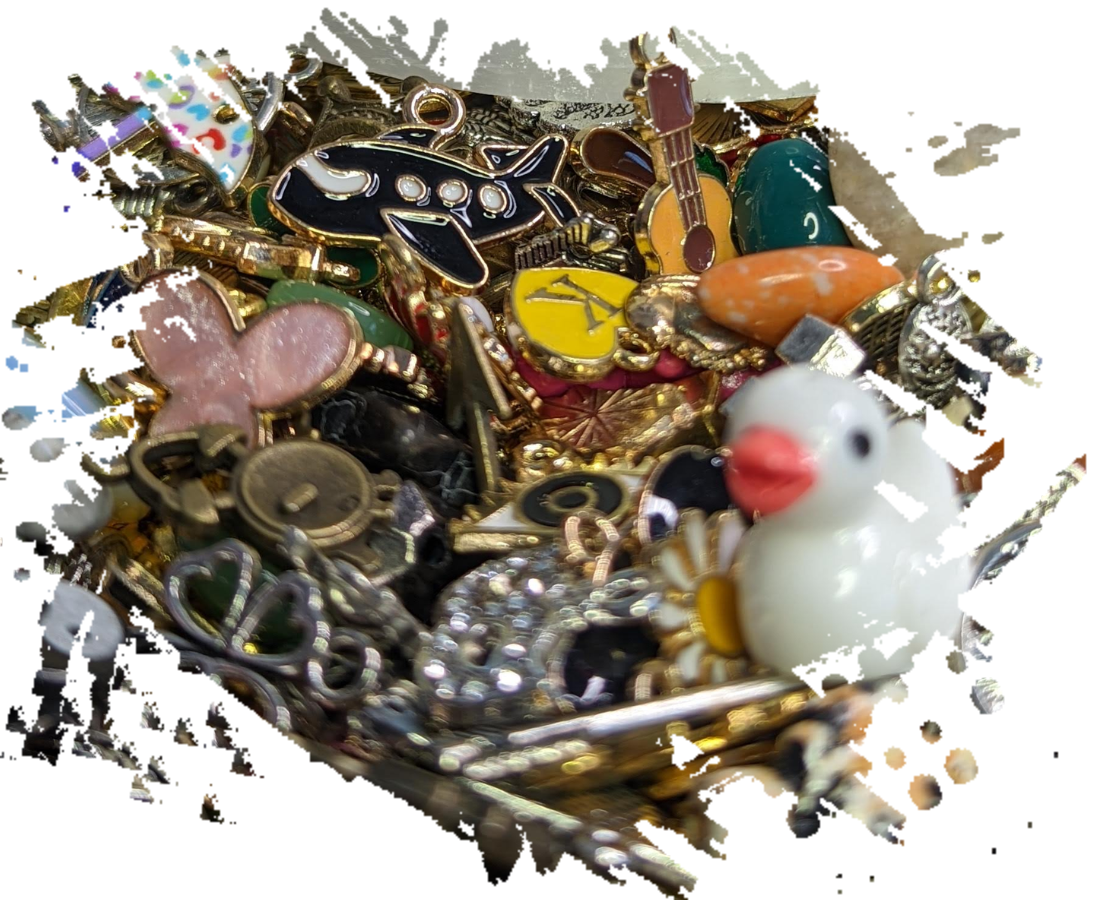 A decorative tin with lid open and many different charms inside and multiple closed tins of different designs and colors