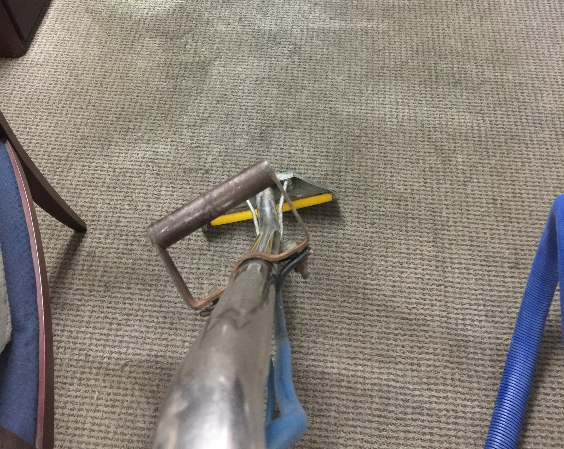 A pair of pliers is sitting on a carpet next to a pair of sandals.