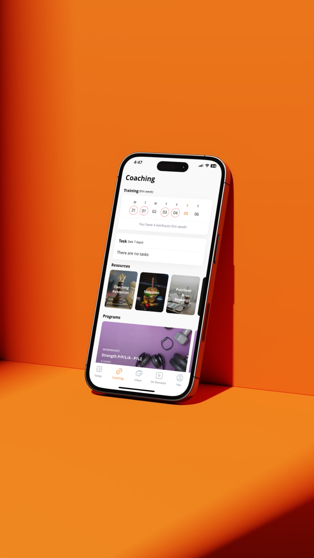 A smartphone displaying a fitness app interface rests against an orange surface.