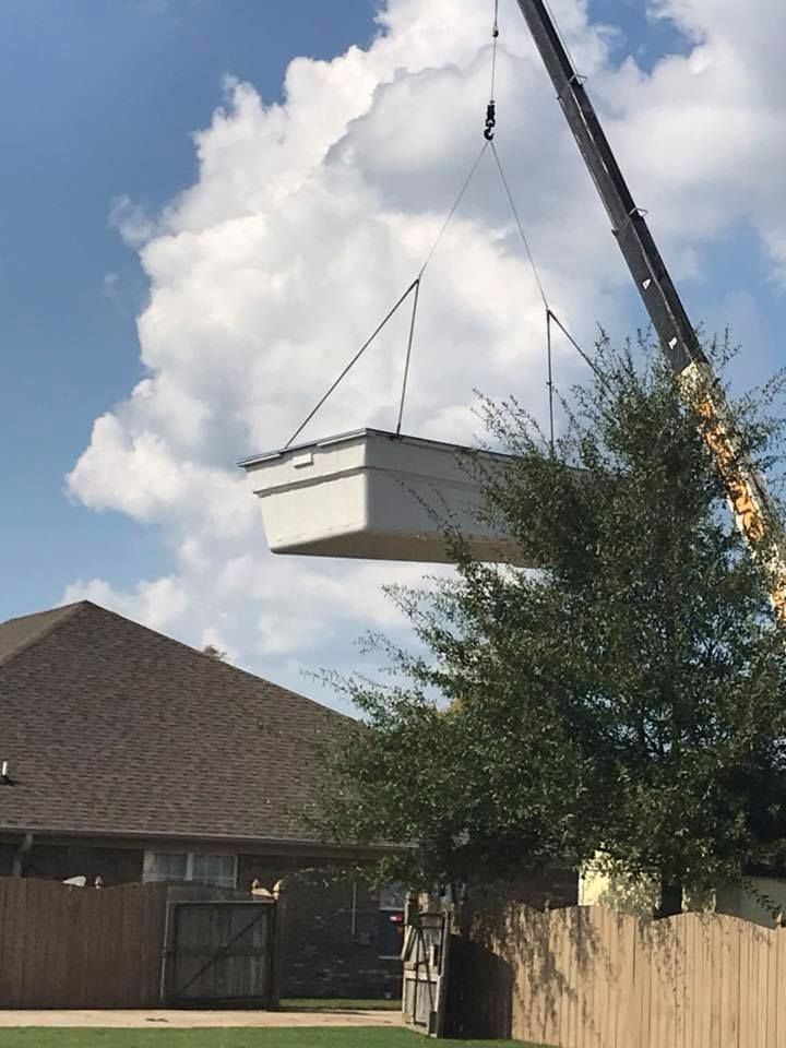 A Crane is Lifting a Swimming Pool Into a Backyard - Madison, AL - Valley Pools