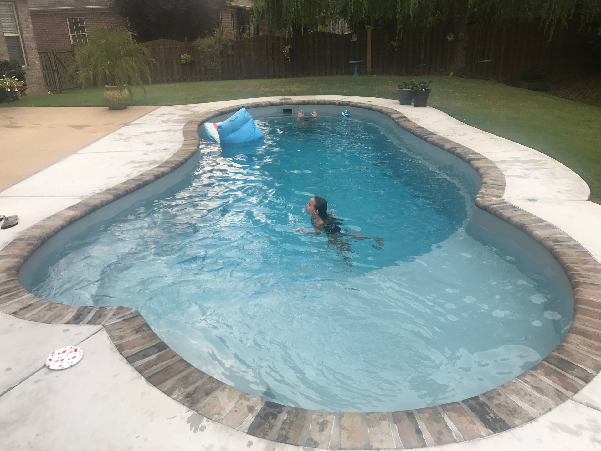 A woman is swimming in a large swimming pool. - Madison, AL - Valley Pools