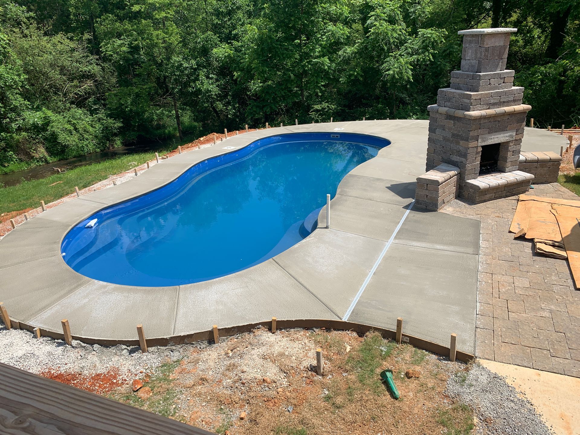A large swimming pool with a fireplace in the backyard. - Madison, AL - Valley Pools