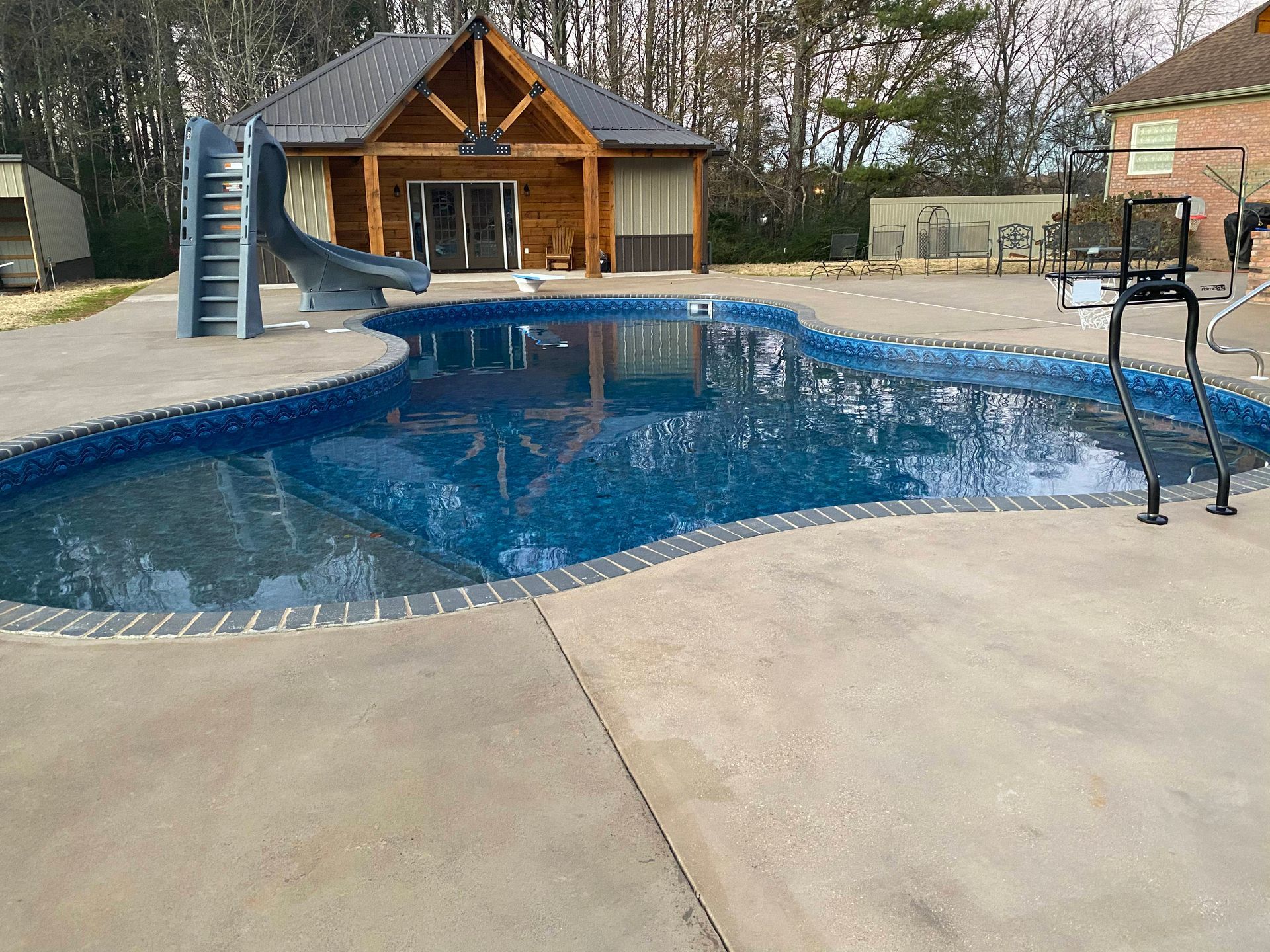 A large swimming pool with a slide in the backyard - Madison, AL - Valley Pools