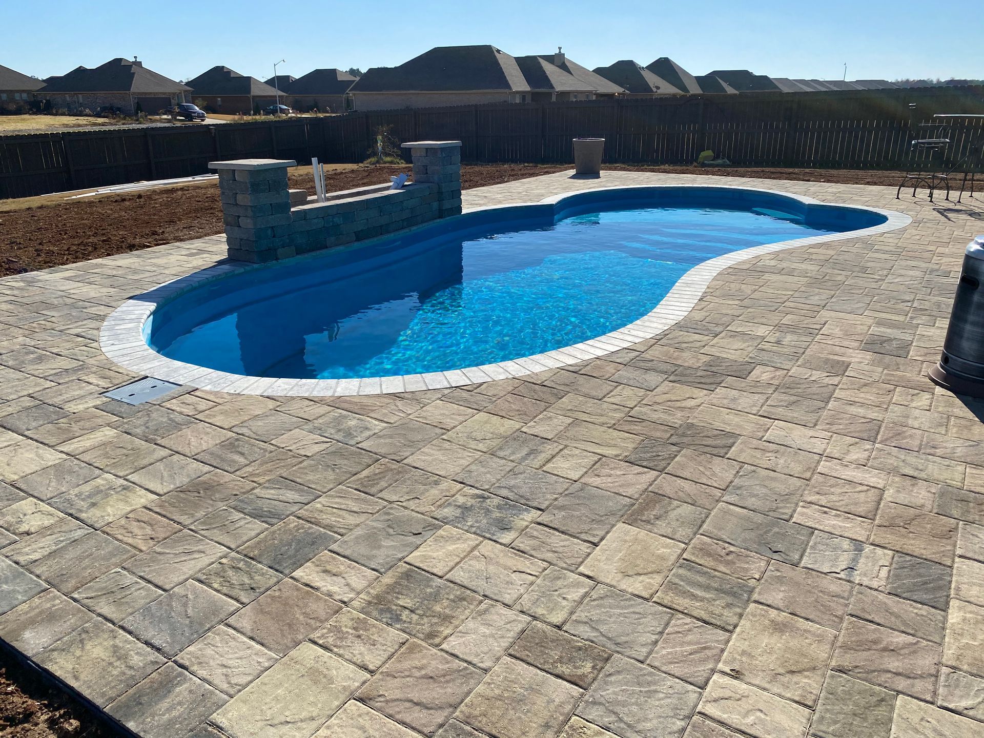 A large swimming pool is surrounded by a brick patio. - Madison, AL - Valley Pools