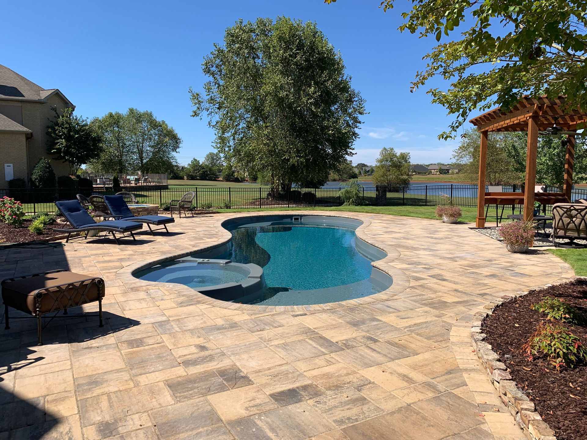 A large swimming pool is surrounded by a patio and chairs. - Madison, AL - Valley Pools
