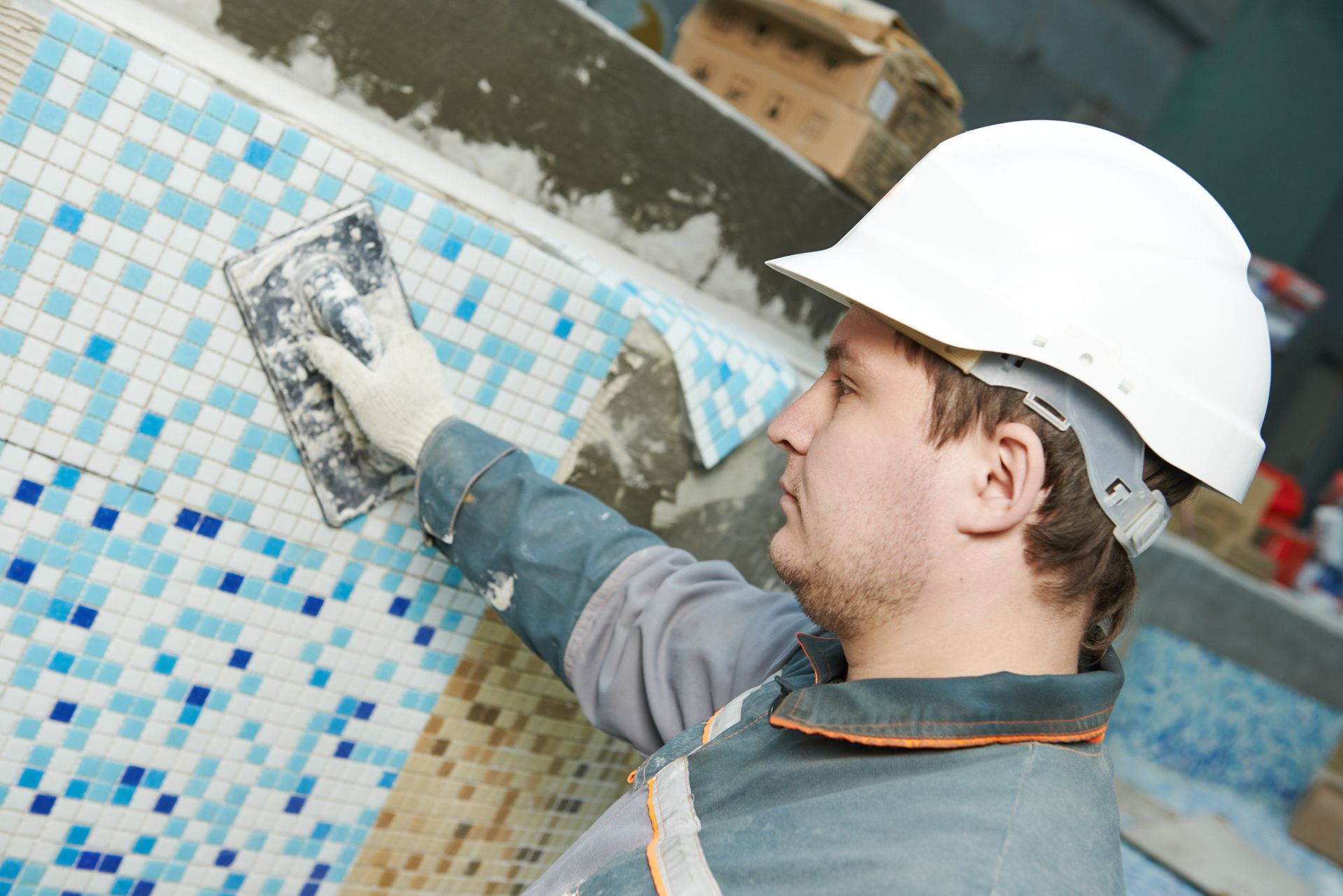 Worker installing floor tile at repair renovation work.