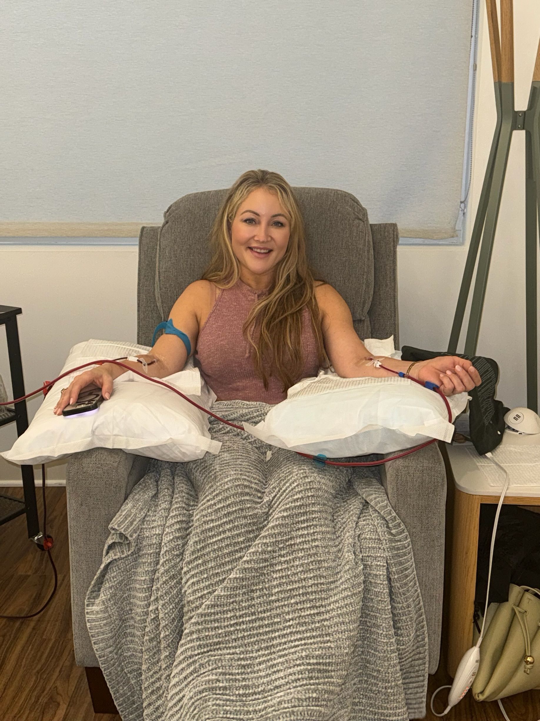 Person drawing blood from their wrist with a syringe; red blood visible.