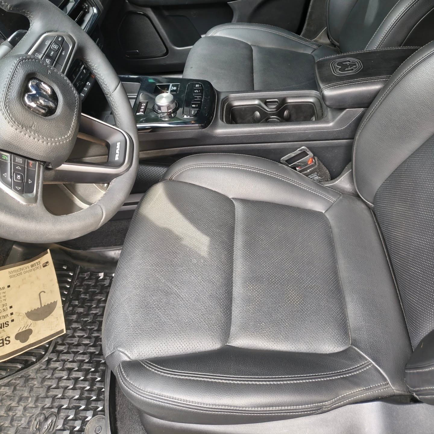 Interior de coche de cuero negro con volante, consola central y asiento