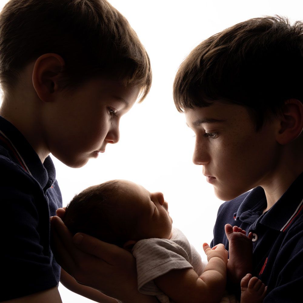 Brothers and their newborn baby brother at toy box baby photoshoot in Braintree Essex
