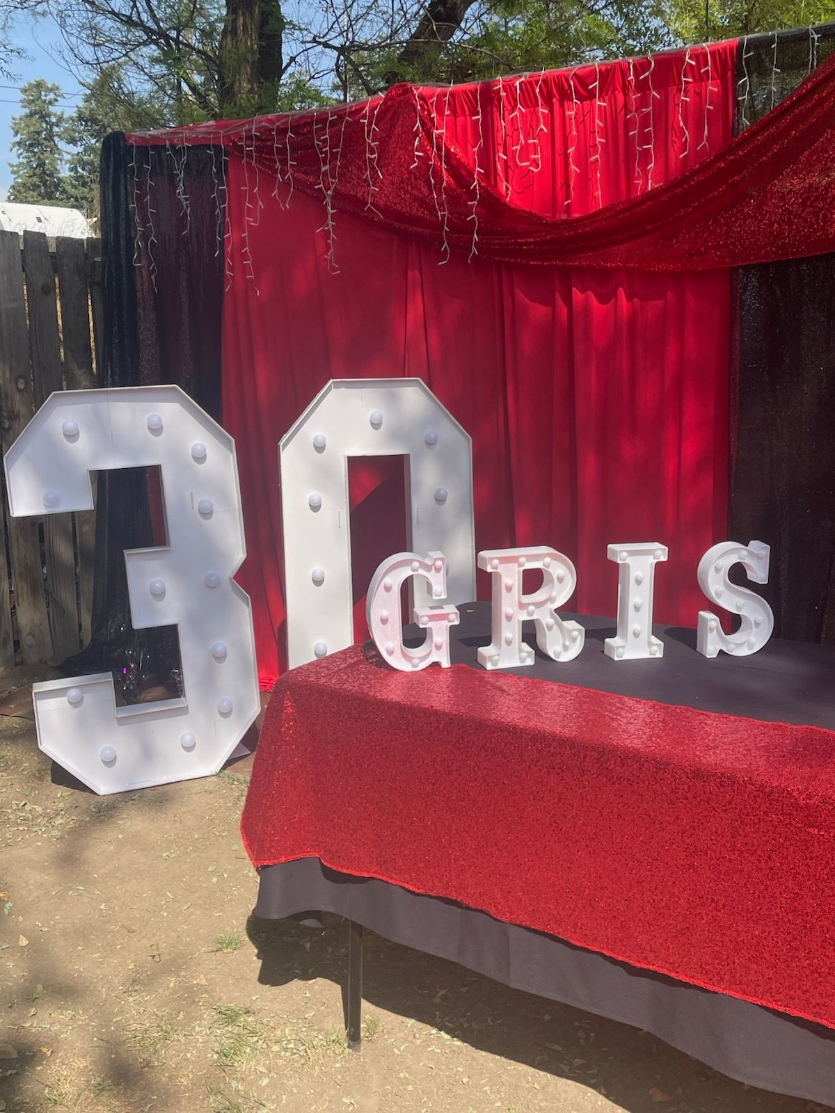 Red and white 30th birthday party decorations. Marquee numbers, the name 