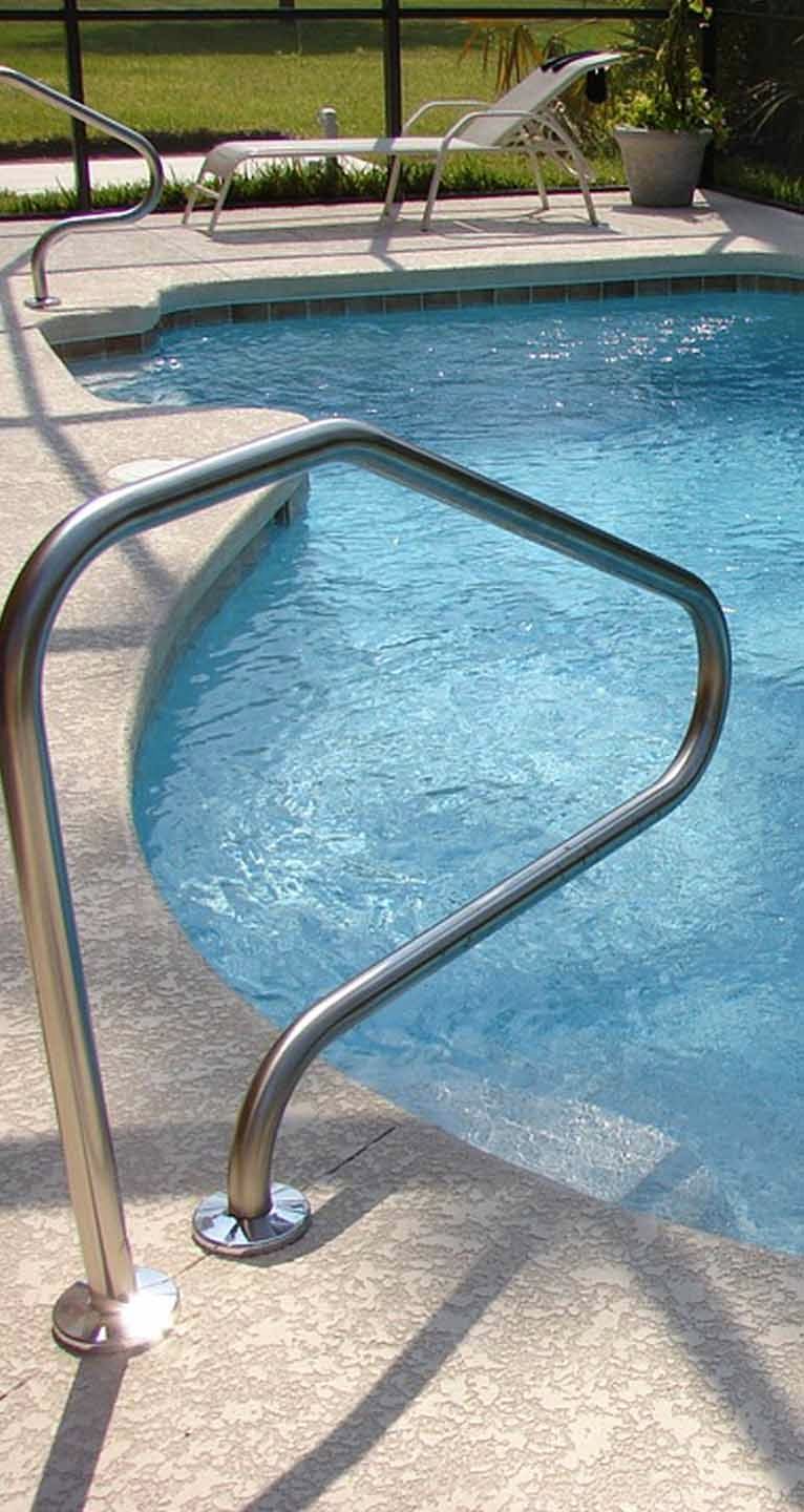 A swimming pool with a staircase leading to it and a chair in the background.