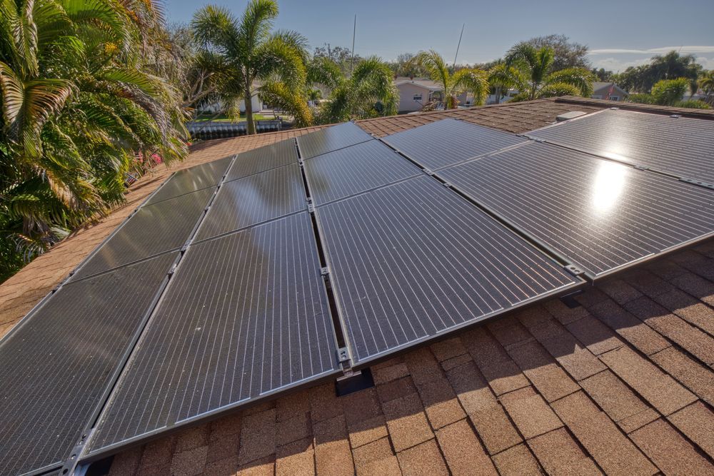 A row of solar panels with a cloudy sky in the background