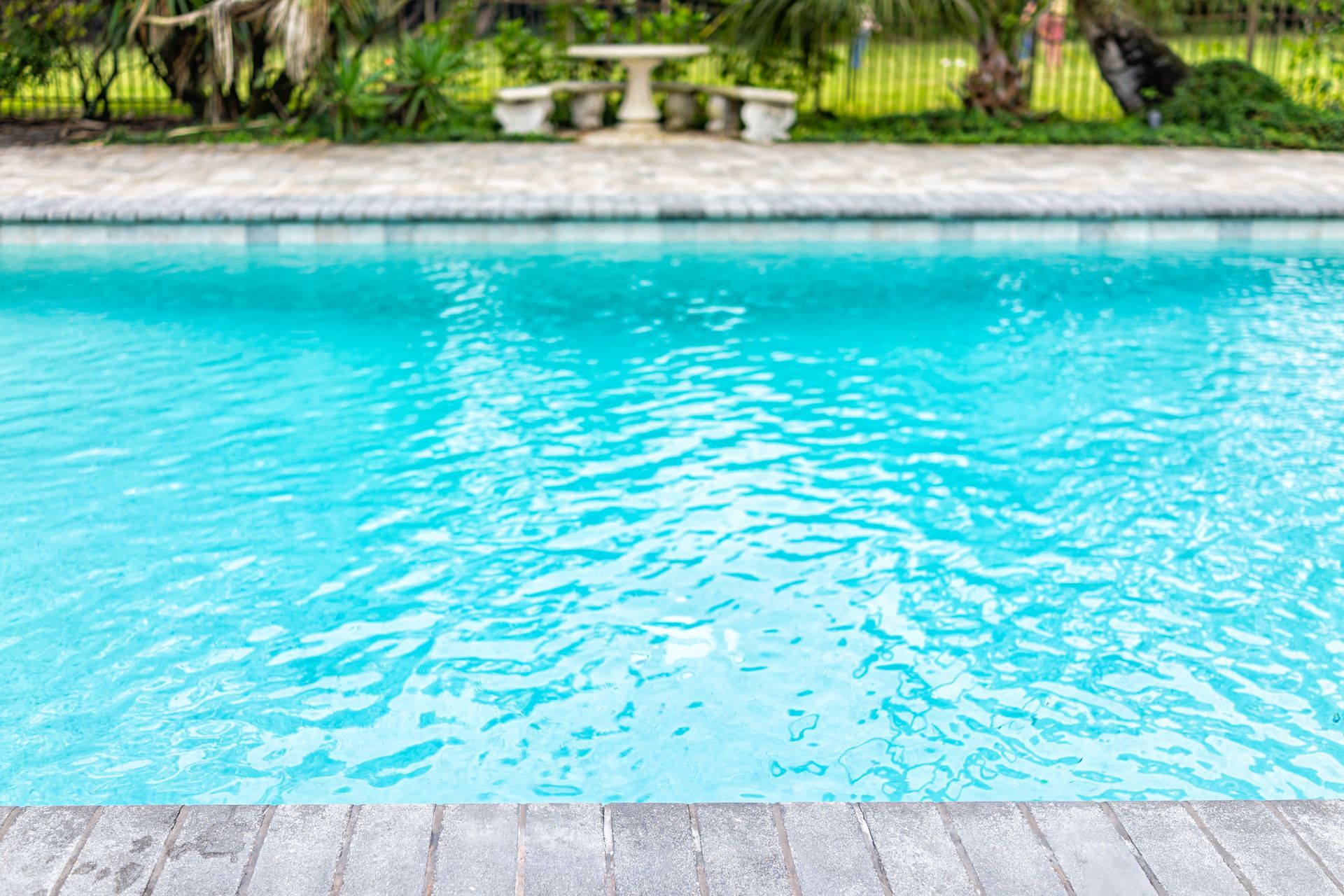 A large swimming pool with a picnic table in the background.