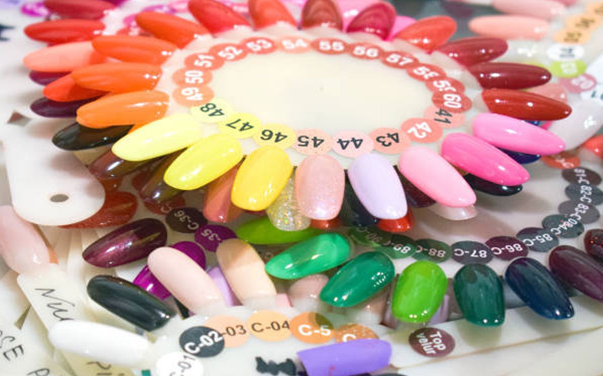 A bunch of different colored nails are arranged in a circle