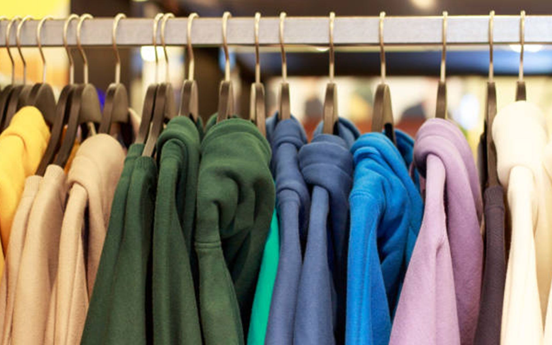 A row of clothes hanging on a rack in a store.