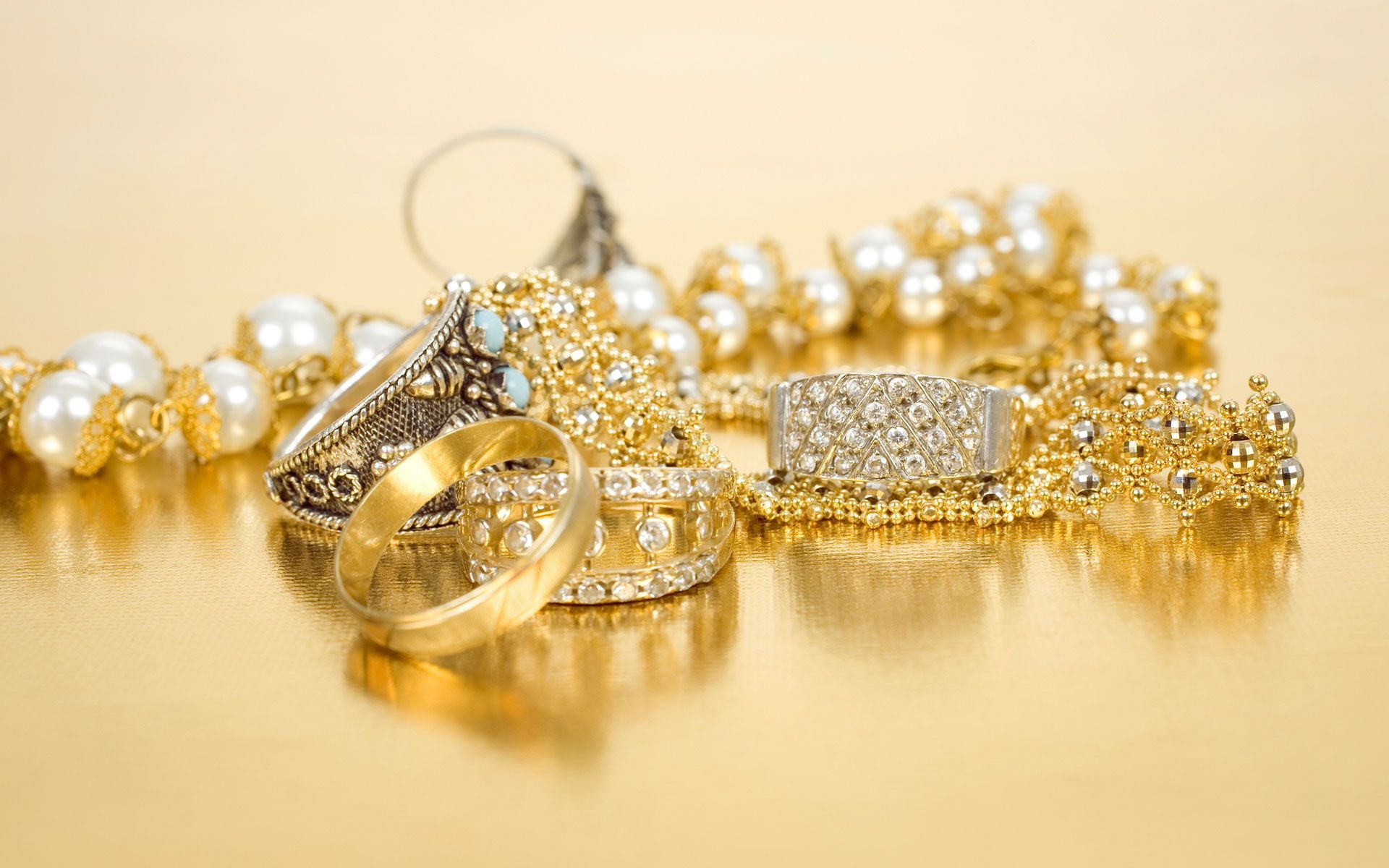 There are many different types of gold jewelry on the table.