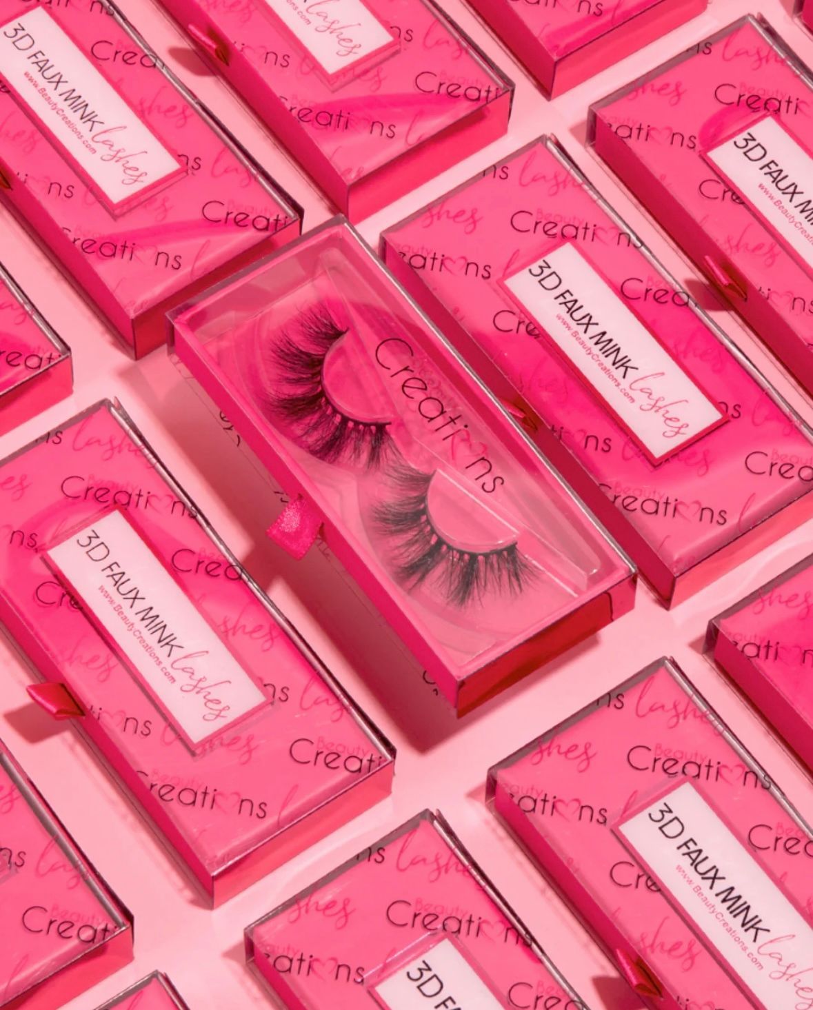 A pair of fake eyelashes sitting on top of a table next to makeup brushes and sponges.