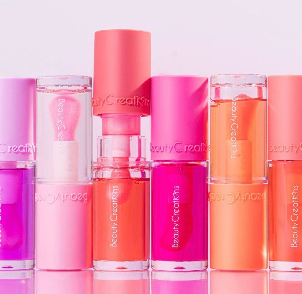 Several bottles of beauty creations are lined up in a row.