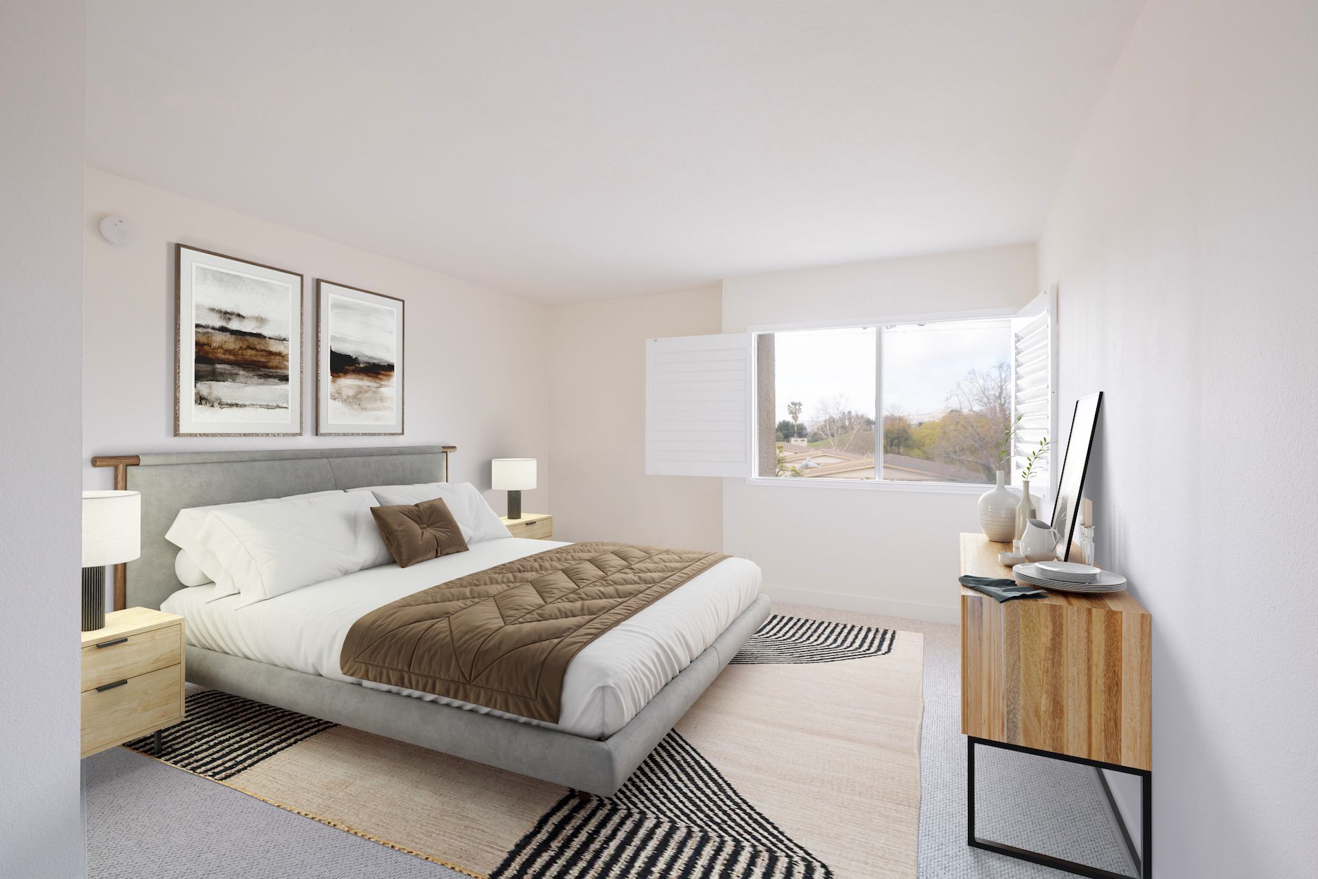 Bright bedroom with bed, nightstands, artwork, and a patterned rug.